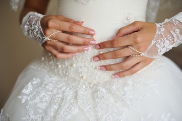 Bride hands on wedding dress