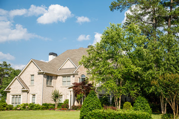 Brick Home with Nice Landscaped Lawn under Nice Skies