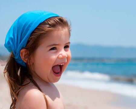 Bambina al mare che ride