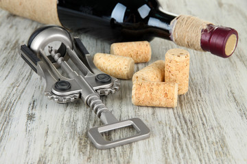 Corkscrew with wine corks and bottle of wine