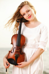 The blonde girl with a violin outdoor