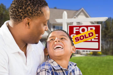 Mixed Race Father and Son In Front of Real Estate Sign and House