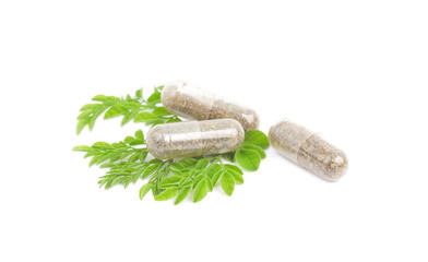 herbal medicine pills with green plant on white background