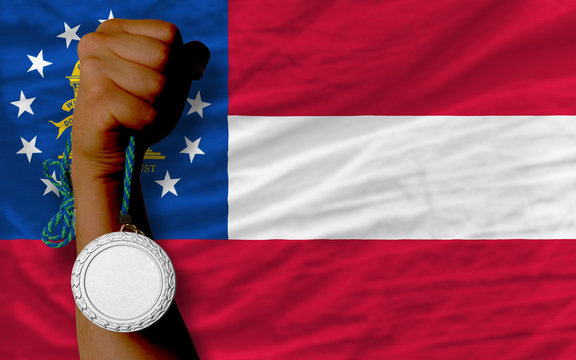 Silver medal for sport and flag of american state of georgia
