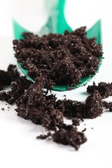 Trowel with soil on white wooden background. Selective focus.