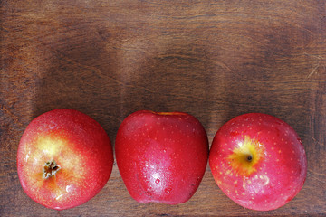 Three apples on wood
