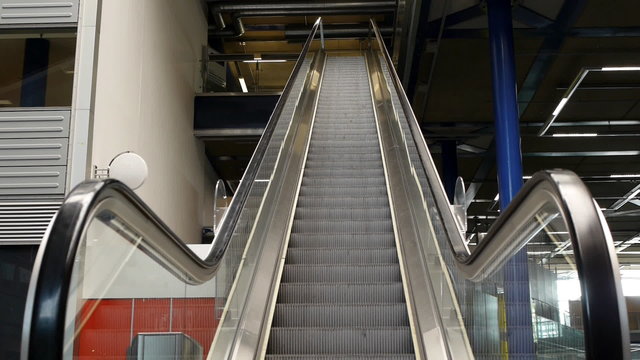 An escalator going up with no people on it.