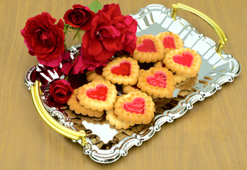 Heart-shaped cookies and roses on a metal tray