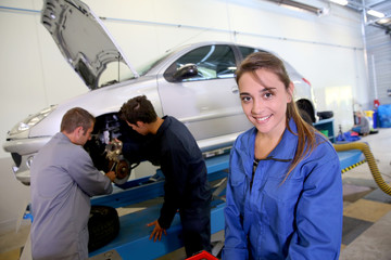 Smiling young woman in auto mechanics training class