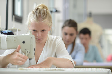 Student girl in training class working on sewing machine