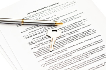 Mortgage assumption agreement with a pen for signature and a key