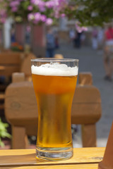 Glass of beer in restaurant on the table outdoor in the sun