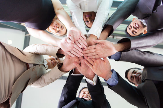 underneath view of business people hands together