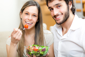 Couple eating a salad in the living room