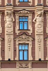 Fototapeta na wymiar The facade of the building with antique sculptures.