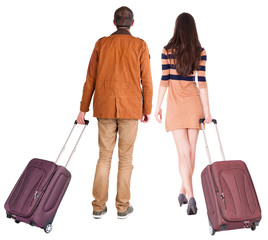 back view of walking  couple  with suitcase.