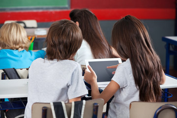 Schoolgirl Using Digital Tablet At Desk
