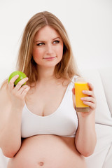 pregnant woman holding an apple and juice