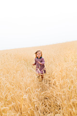 Naklejka na ściany i meble BAby girl at the wheat field