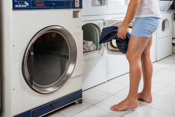 Man Putting Clothes In Washing Machine