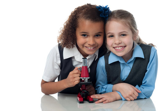 Young little school girls with microscope