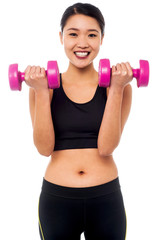 Happy fitness woman lifting dumbbells