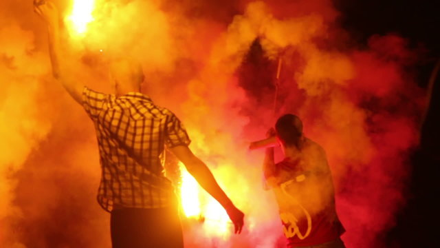 Smokes and fires, man spinning burning chain fire pois night