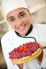 Portrait of pastry cook girl holding cake