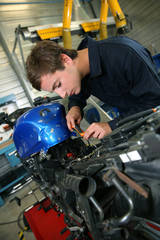 Teenager in professional training, repairing motorbike