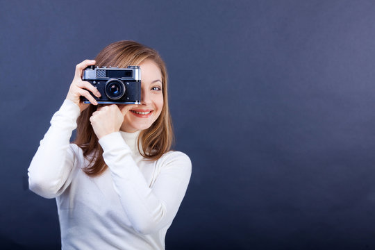 beautiful girl with a photo camera on a dark blue background