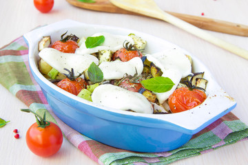 Mixed vegetable in blue bowl baked in the oven with cheese and b