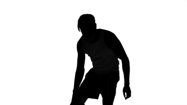 Silhouette of a man playing basket