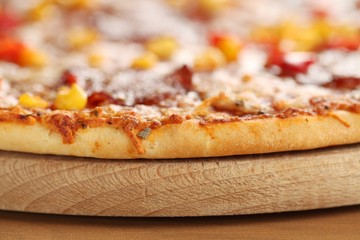 Close-up of pizza on wooden tray. Selective focus,shallow DOF.