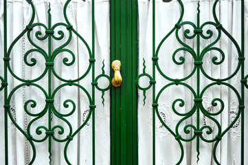 Puerta con reja y llamador de bronce