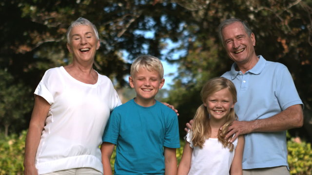 Grandchildren and grandparents posing in a park in slow motion