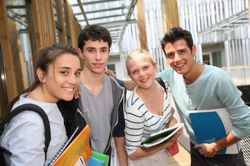 Cheerful students standing outside school building