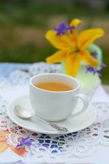 Сup of tea with a lily on a background