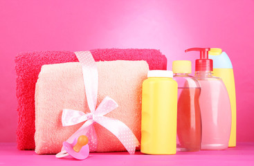 Obraz na płótnie Canvas Kosmetyki dla dzieci i ręczniki na różowym tle