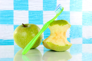 Apples with a toothbrush on shelf in bathroom