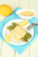 Asparagus on plate, on wooden background