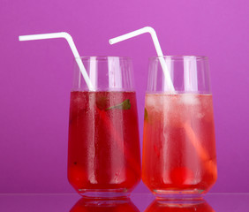 Two cherry cocktails with ice on purple background