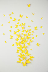 Paper yellow butterflies fly on wall in different directions