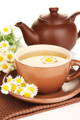 Cup of herbal tea with camomiles close up