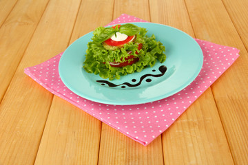 Tasty roasted marrow and tomato slices with salad leaves,