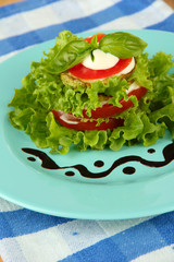 Tasty roasted marrow and tomato slices with salad leaves,