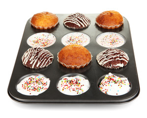 Tasty muffin cakes in baking tray isolated on white