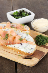 Fish sandwiches on cutting board on wooden table