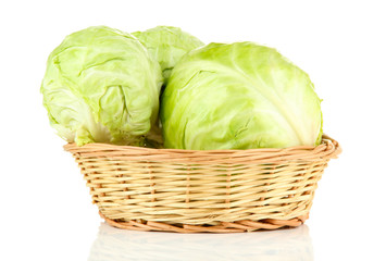 Green cabbage in wicker basket, isolated on white