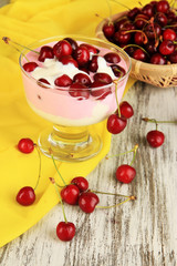 Delicious cherry dessert in glass vase on wooden table close-up