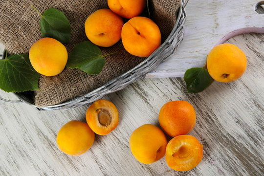 Apricots in basket on wooden table